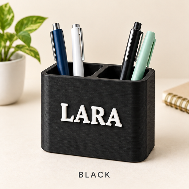 Black two-slot pen holder with the name LARA in raised white letters, holding pens