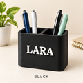 Black two-slot pen holder with the name LARA in raised white letters, holding pens