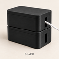 Two stacked black cable boxes with lids, a white cable running out of the side slot