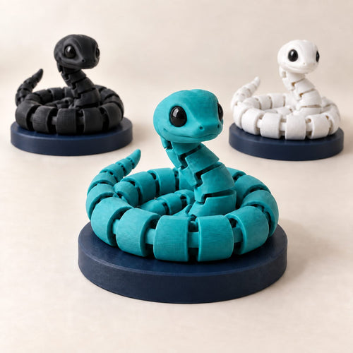 Teal articulated snake coiled on a round navy base, with black and white snakes behind it