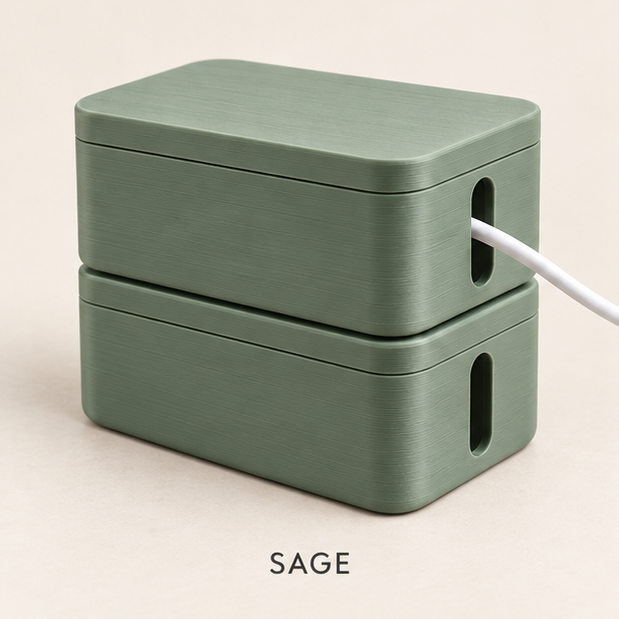 Two stacked sage green cable boxes with lids, a white cable running out of the side slot