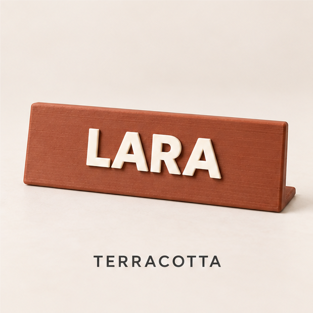 Terracotta desk nameplate with raised cream letters spelling LARA