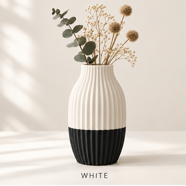 Ribbed vase, cream on top and black at the base, holding dried flowers