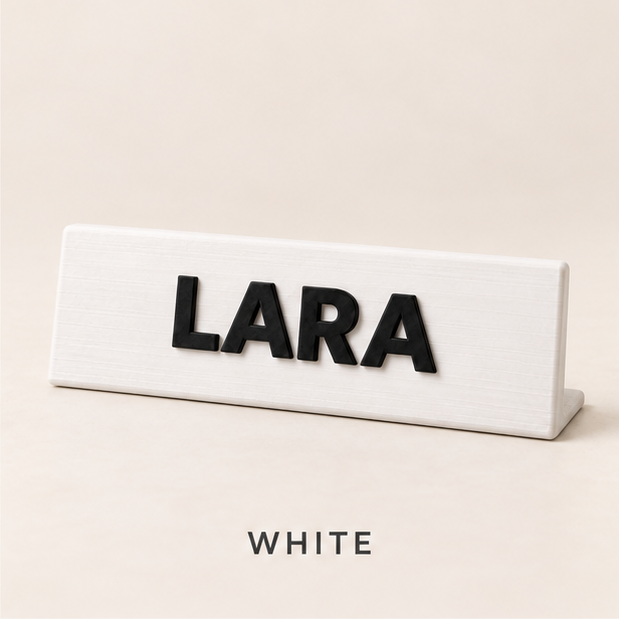 White desk nameplate with raised black letters spelling LARA