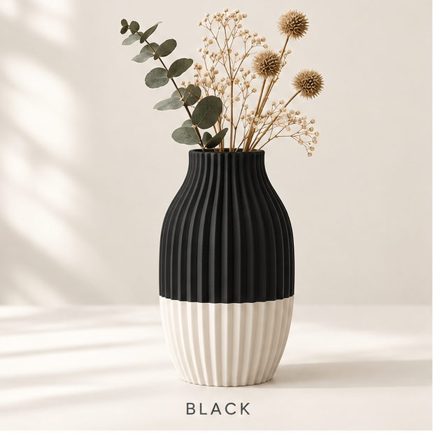 Ribbed vase, black on top and cream at the base, holding dried flowers