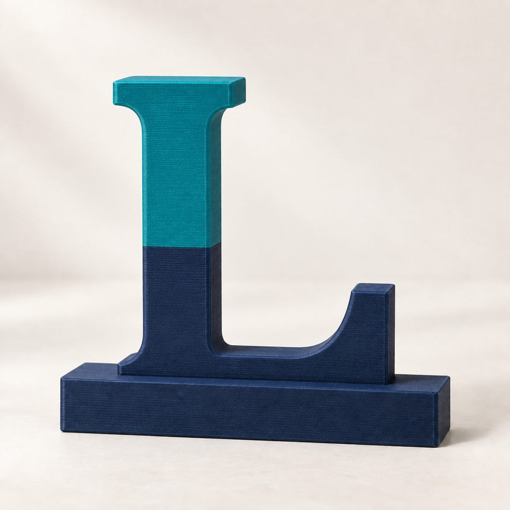 Letter L monogram stand split teal over navy, on a flat base